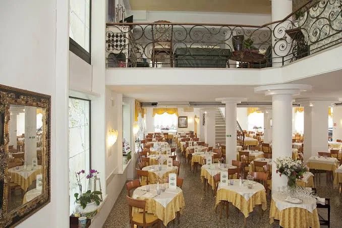 Hotelová restaurace hotelu Elpiro v Lido di Jesolo v Itálii s prostřenými stoly, možnost stravování během dovolené u moře.