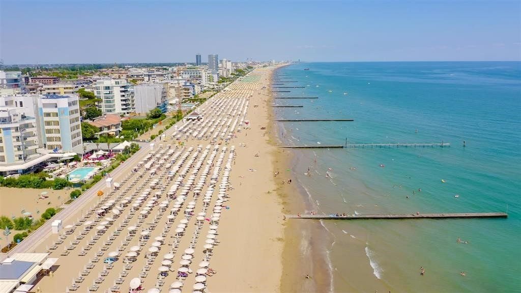 Letecký pohled na dlouhou písečnou pláž v Lido di Jesolo v Itálii u Jaderského moře, oblíbená destinace pro letní dovolenou.