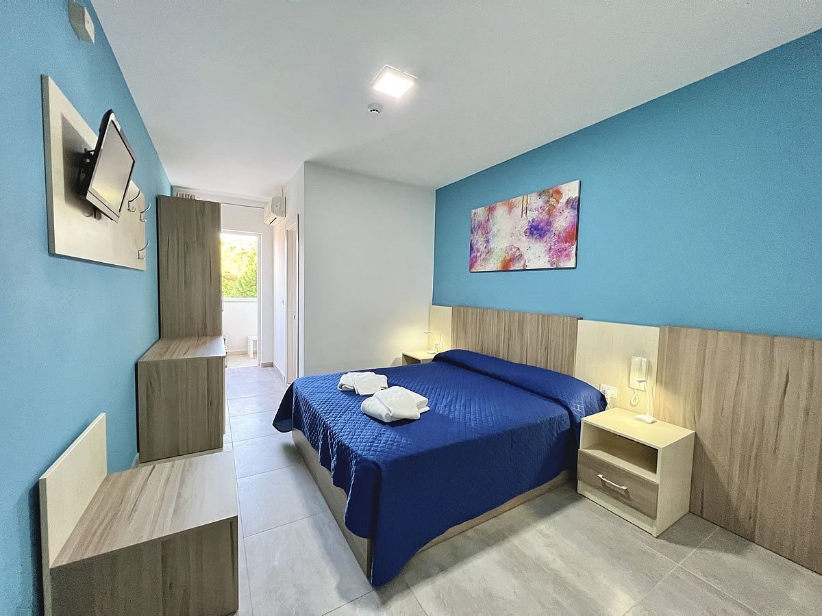 Moderní pokoj s manželskou postelí v hotelu Old River v Lignano Riviera v Itálii, komfortní ubytování pro dovolenou u moře.