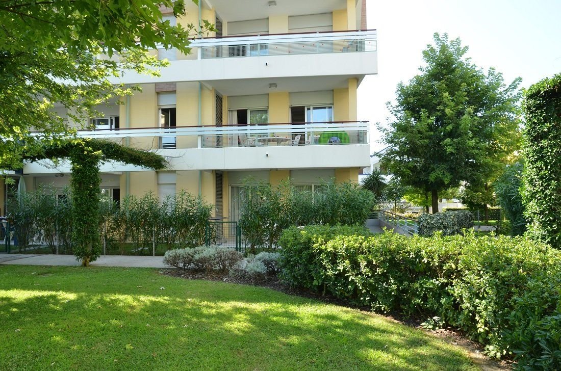 Apartmánový dům Villaggio Planetarium Resort v Bibione v Itálii obklopený zahradou a zelení, komfortní ubytování pro rodinnou dovolenou u moře.
